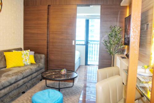 a living room with a couch and a table at Air Residences-Stylish&Comfort Stay High flat with balcony in Manila