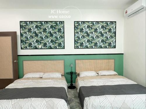 two beds in a room with green and white at NanYang Style Kluang Holiday Suites in Kluang