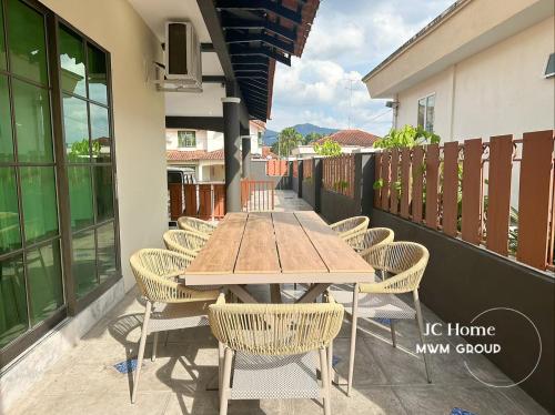 a wooden table and chairs on a balcony at NanYang Style Kluang Holiday Suites in Kluang