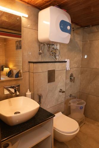 a bathroom with a sink and a toilet at Sansa By The Woods - Manor&Spa in Mussoorie