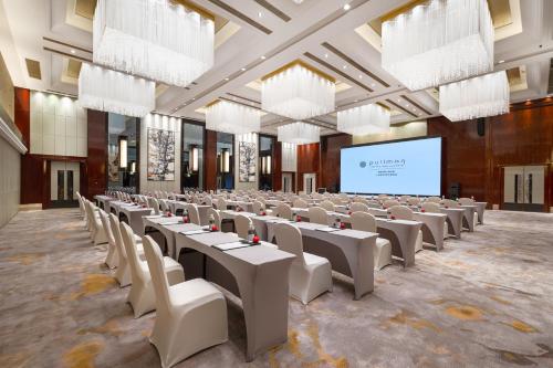 a large room with tables and chairs and a screen at Pullman Shanghai Jing'an-Jing'an district, downtown railway station, traffic hub, easy to travel Shanghai in Shanghai