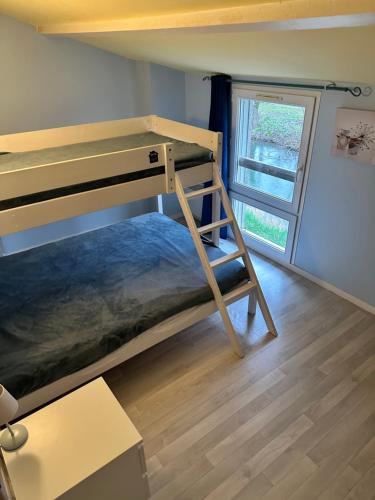 Ce lit superposé se trouve dans un dortoir doté d'une fenêtre. dans l'établissement Relais Venise verte, à Coulon