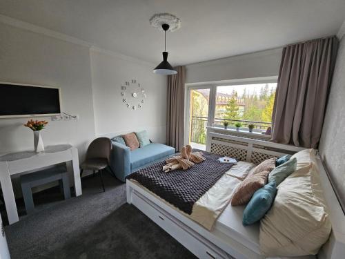 a bedroom with a bed and a desk and a window at Apartmán Filip wellness,krytý bazén in Tatranska Strba