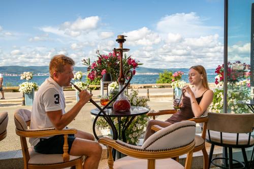 a man and woman sitting in chairs at a table at Paradiso Dreams Hotel in Nesebar