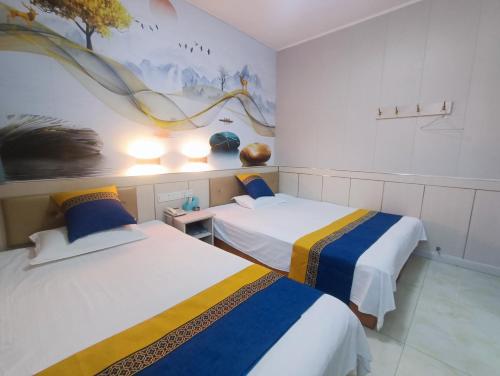 a room with two beds and a painting on the wall at Qufu Garden Hotel in Qufu
