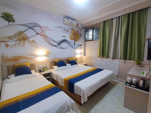 a bedroom with two beds and a painting on the wall at Qufu Garden Hotel in Qufu