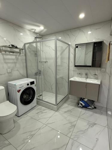a bathroom with a shower and a washing machine at Comfy classic apartment in Central UB in Ulaanbaatar