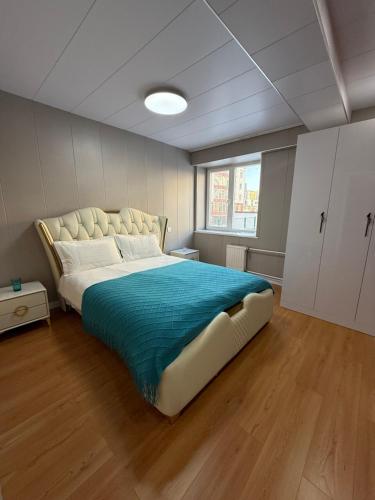 a bedroom with a large bed with a blue blanket at Comfy classic apartment in Central UB in Ulaanbaatar