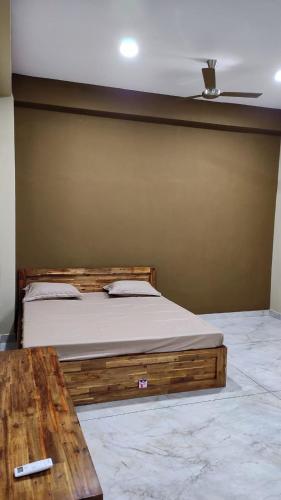a bedroom with a bed and a wooden table at malnad at mysore in Hārohalli