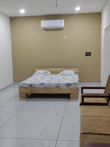 a bedroom with a bed and a air conditioner on the wall at malnad at mysore in Hārohalli