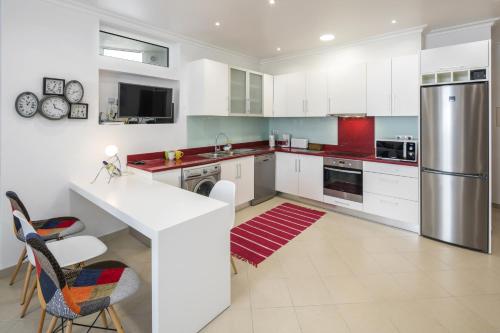 a kitchen with white cabinets and stainless steel appliances at Apt. À Porta in Lagos