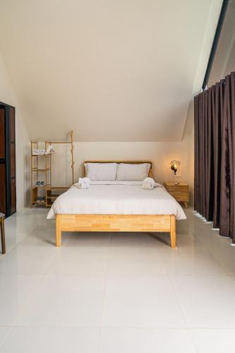 a bedroom with a large bed with white sheets at Kawaland glamping resort in Telukbakau