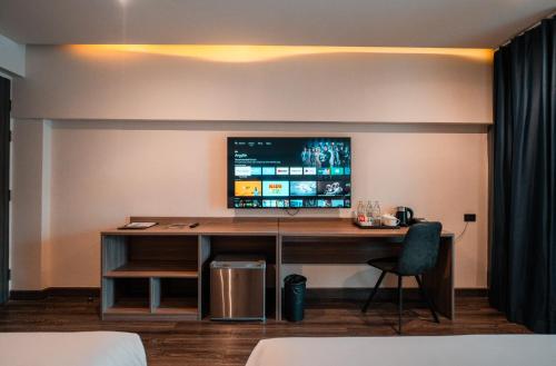 a room with a desk with a tv on the wall at SureStay by Best Western Iconic Ari-Jatujak in Bangkok