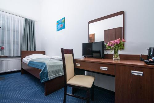 a hotel room with a bed and a desk with a mirror at Marina Wolin in Wolin