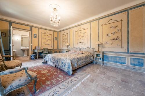 une chambre avec un lit et une chaise dans l'établissement Château de Cristin du XVIII, authentique et familial - ROSSIconciergerie, à Junas