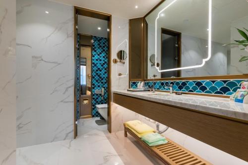 a bathroom with a sink and a mirror at Bliss International Hotel in Weihai