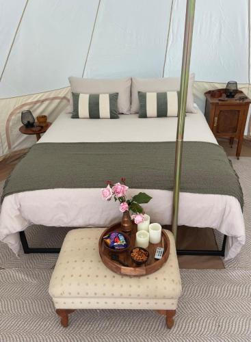 a bed with a tray of food and flowers on a table at Fairy Wren Off Grid Luxury Glamping Retreat in Wine Country in Lilydale