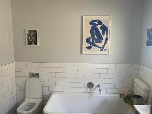 a bathroom with a white tub and a toilet at The Ashlyn Retreat Shepparton in Shepparton