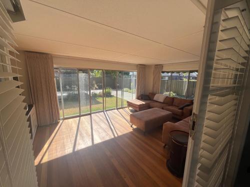 a screened in porch with a couch and a table at The Ashlyn Retreat Shepparton in Shepparton