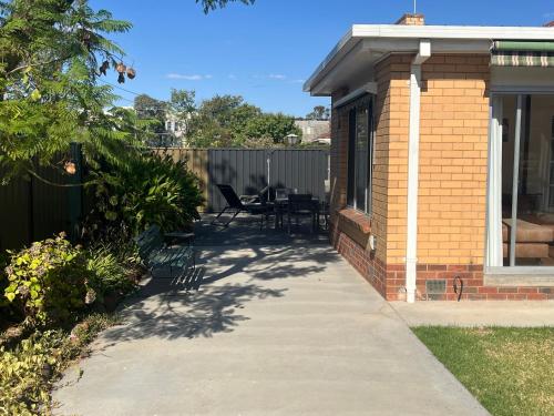a patio of a house with a table and chairs at The Ashlyn Retreat Shepparton in Shepparton