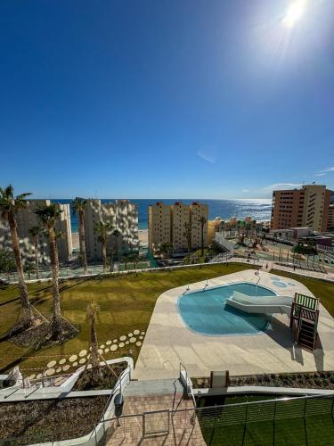 a swimming pool with the ocean in the background at Sunset Cliffs Wellness & Spa by Leo Apartments Benidorm in Benidorm