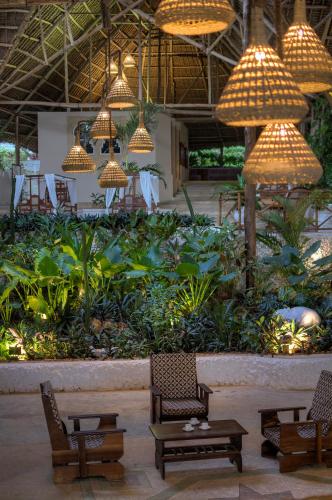 a lobby with chairs and lights and plants at Diamonds Mapenzi Beach in Kiwengwa