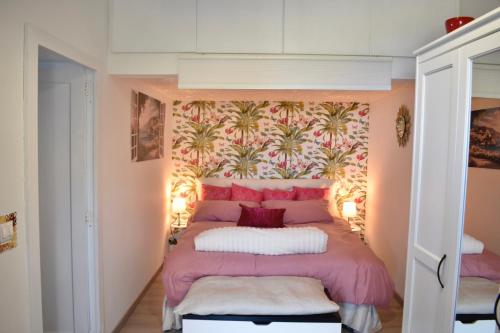 a bedroom with a bed with a pink head board at ViDa Home in Castelmola