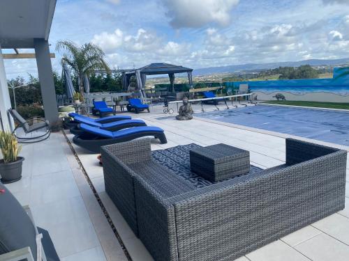 un patio con mobili in vimini e una piscina di Alto do Moinho ad Alcobaça