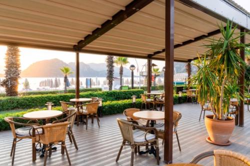 a patio at a restaurant with tables and chairs at Hotel Aqua in Marmaris
