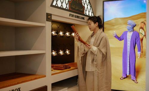 a woman standing next to a mannequin in a store at StayPassport Morocco Spa Incheon Songdo in Incheon