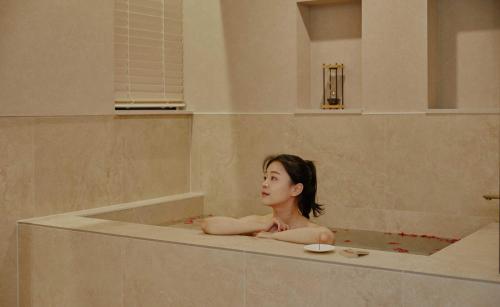 a woman is sitting in a bath tub at StayPassport Morocco Spa Incheon Songdo in Incheon