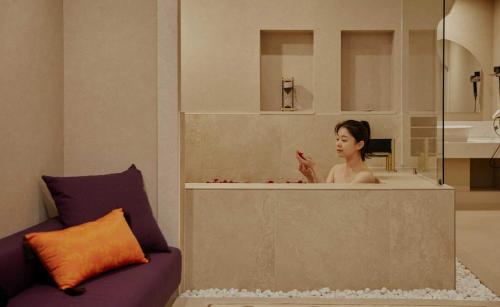 a woman taking a bath in a bath tub at StayPassport Morocco Spa Incheon Songdo in Incheon