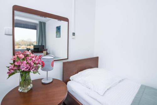 a bedroom with a bed and a vase of flowers on a table at Marina Wolin in Wolin