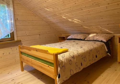 a bedroom with a bed in a log cabin at Oaza Ławki in Ryn