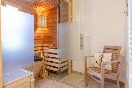 Habitación con silla y pared de cristal. en FriesenLodge, en Utersum