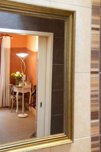 a mirror reflecting a room with a table and a dining room at Le Petit Saint-Julien in Saint-Julien-les-Villas