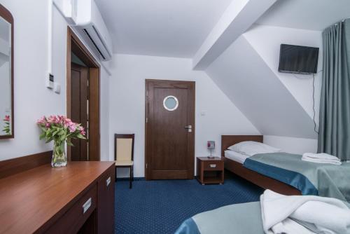 a hotel room with two beds and a table at Marina Wolin in Wolin