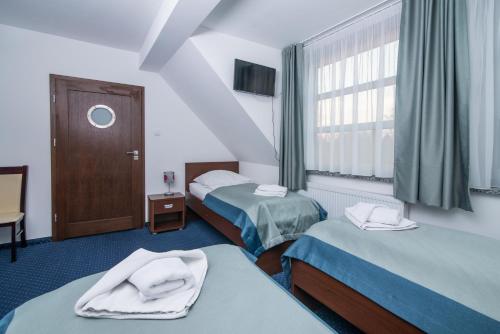 a hotel room with two beds and a window at Marina Wolin in Wolin