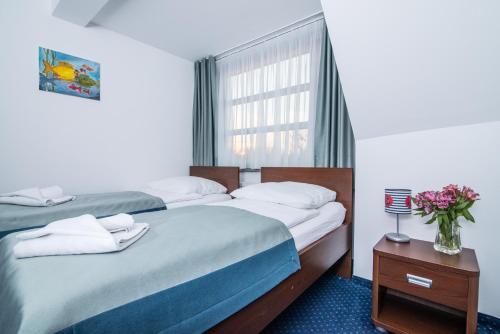 a bedroom with two beds and a window at Marina Wolin in Wolin