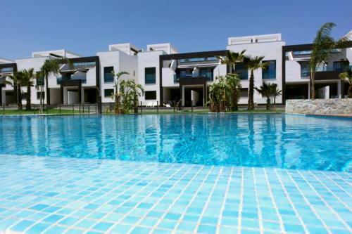 a large swimming pool in front of a building at Punta Prima & Oasis Beach apartment in Punta Prima