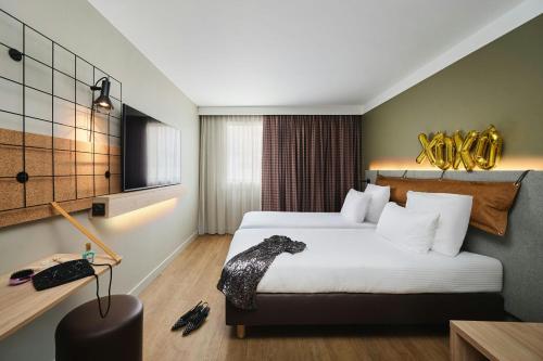 a hotel room with a large bed and a desk at Moxy Annecy in Annecy