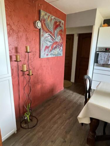 une salle à manger dotée d'un mur rouge avec une table et une table dans l'établissement Zen house with a view, à Manosque