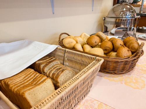 a table with two baskets of bread and baskets of bread at Aparthotel Pineda in Bibione