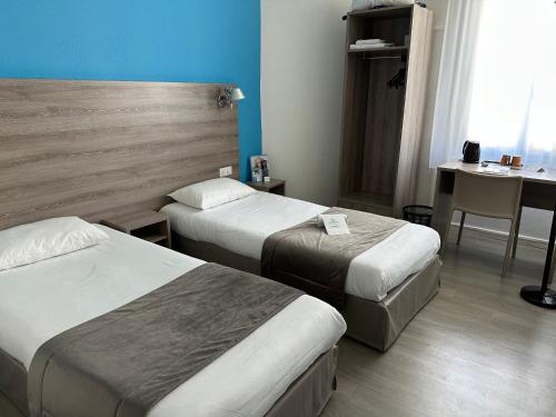 a hotel room with two beds and a desk at BRIT HOTEL CONFORT NEVERS Centre Gare in Nevers
