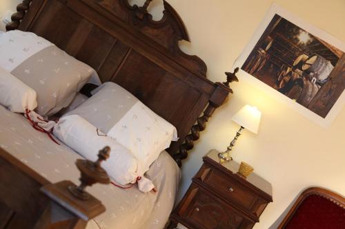 a bedroom with a bed with a wooden head board at Maison d'Hôtes Lassaubatju in Hontanx