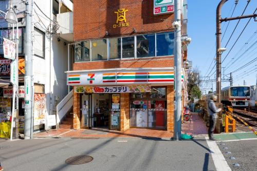 a building on the side of a street with a train at Brio Takaido in Tokyo