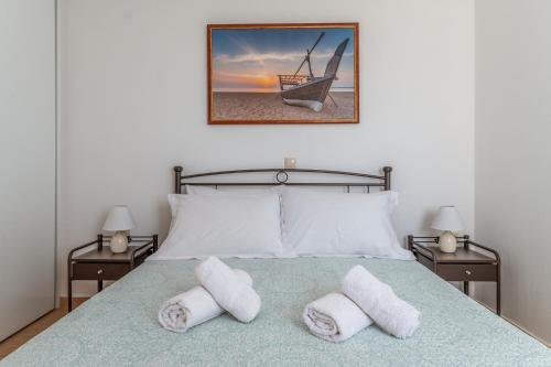 a bedroom with a bed with two towels on it at Archontiko Keli in Katákoilos