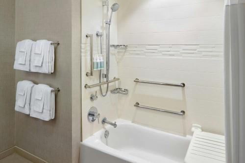 a bathroom with a tub and a shower with towels at Residence Inn by Marriott Portland Downtown/Pearl District in Portland