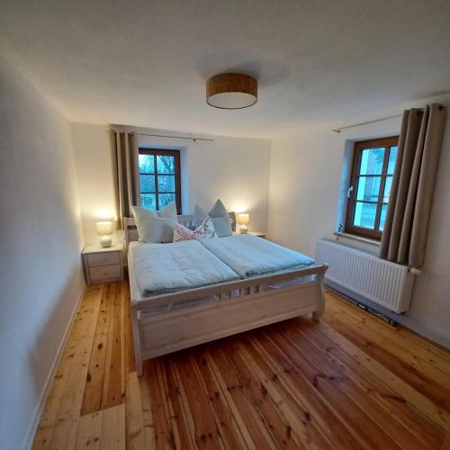 a bedroom with a large bed and two windows at Ferienhaus "An der Kleinen Spree" in Malschwitz