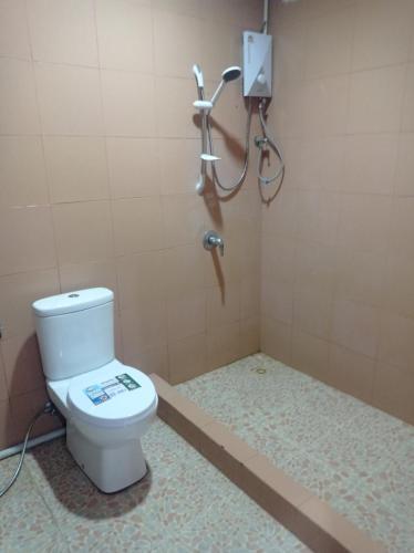 a bathroom with a toilet and a shower at Jasmine Hostel & Guesthouse in Pakse